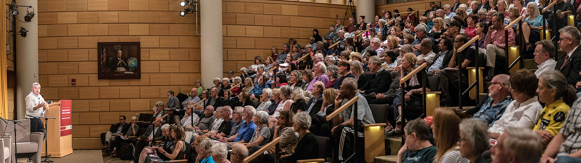 Wide shot of a large audience in the Humphrey School's auditorium