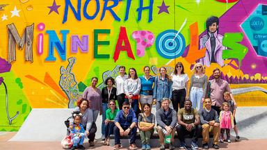 Group shot of CREATE researchers in front of a North Minneapolis mural