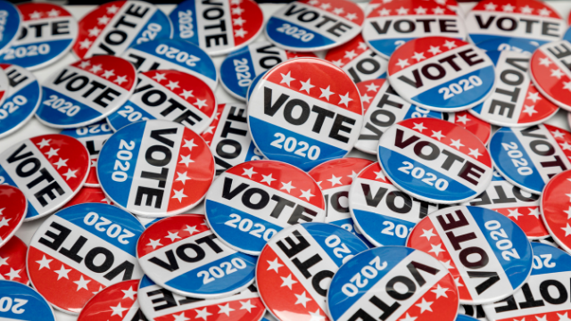 Red, white, and blue "VOTE 2020" buttons scattered across a surface