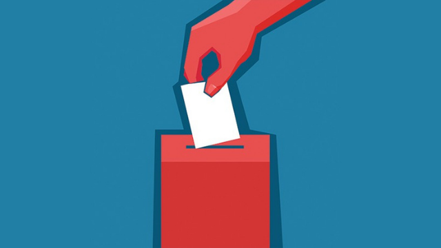 A person puts a ballot in a box