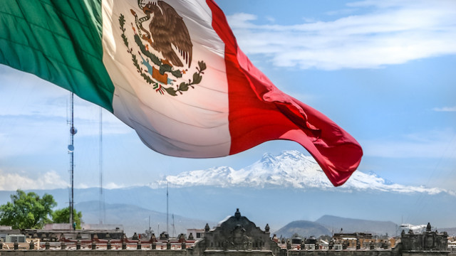 Mexican flag waving in the breeze over cityscape