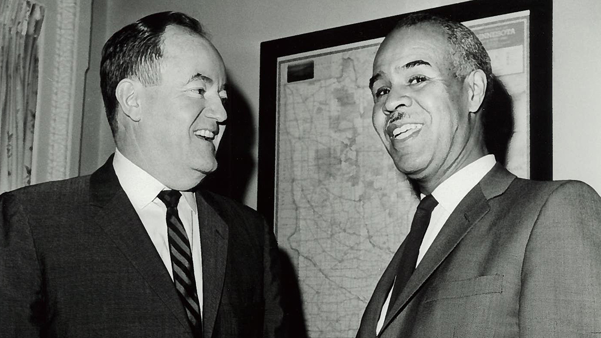 Roy Wilkins and Hubert Humphrey talking to one another.