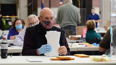 A man sits at a table counting ballots in Anoka County, Minnesota