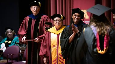 UMN dignitaries on stage at 2023 Humphrey School commencement