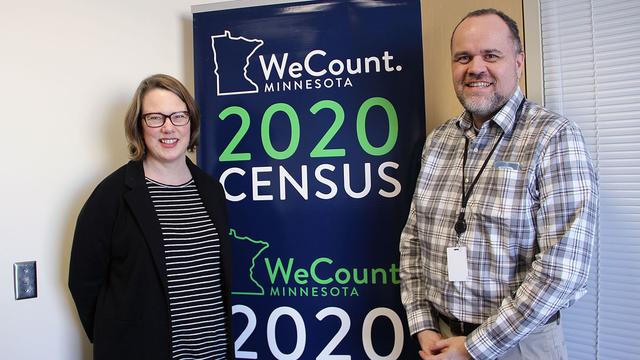 Alumni Susan Brower and Andrew Virden pose with a 2020 census poster
