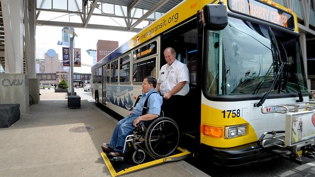A Metro Transit driver assists a passenger in a wheelchair exiting a bus 