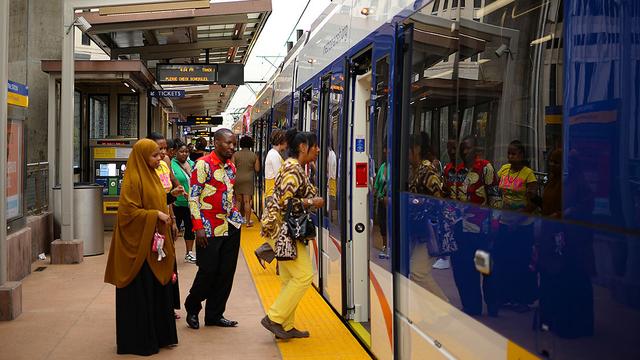 Commuters enter a light rail train at a station in Minneapolis