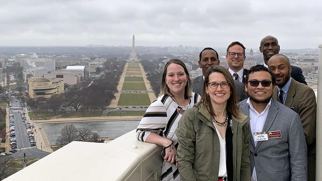 Small group of policy fellows stand outside the US Capitol dome