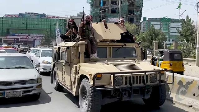 Taliban soldiers ride on a Humvee in Kabul, Afghanistan