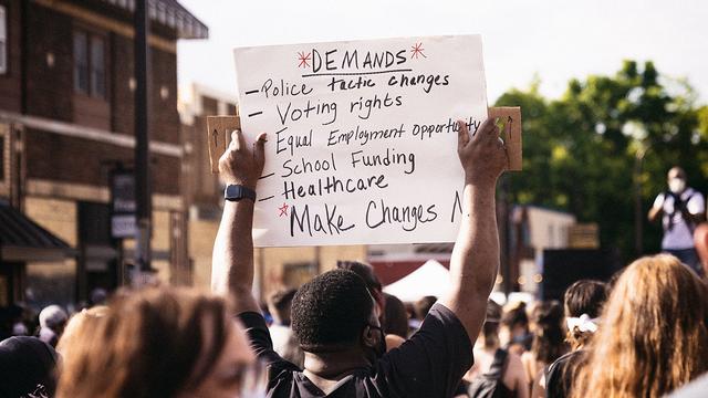 Protesters in Minneapolis after George Floyd's death holding signs