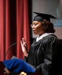 Chanda Smith Baker speaking onstage during the Humphrey School 2023 commencement ceremony