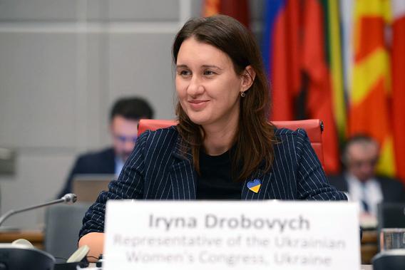 Iryna Drobovych sits at a table at the 2023 OSCE conference