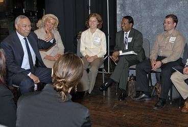Colin Powell and a group of students sitting on chairs in a circle in 2006