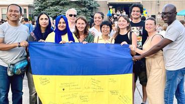 Humphrey International Fellows hold a Ukrainian flag at Ukrainian Independence Day 2023 celebration in Minneapolis 